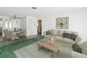 Living room with beige couch, coffee table, and dining area at 7037 Versailles N # 15, Pinellas Park, FL 33781