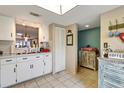 White kitchen cabinets, view into dining area, and laundry closet at 8210 Sulky Ct # 5, Port Richey, FL 34668