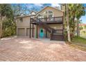 Two-story house with a large brick driveway and a spacious deck at 8711 Betty St, Port Richey, FL 34668