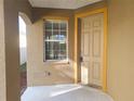 Front entrance with a tan door and yellow trim at 9142 Bell Rock Pl, Land O Lakes, FL 34638