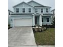 Two-story light blue house with white garage door and landscaping at 10122 Zennia Ln, Parrish, FL 34219