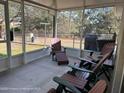 Relaxing screened porch with patio furniture, perfect for outdoor enjoyment at 10329 Calico Warbler Ave, Weeki Wachee, FL 34613