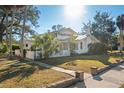 Two-story white house with green roof, lush landscaping, and a long driveway at 106 Banana St, Tarpon Springs, FL 34689