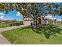 Well-maintained home featuring a manicured lawn, lush landscaping, and an attached two-car garage at 1082 Dartford Dr, Tarpon Springs, FL 34688
