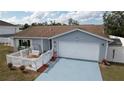 Inviting single-story home featuring blue painted drive, white fence, tidy landscaping, and neutral siding at 11731 Linden Dr, Spring Hill, FL 34608