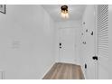 Bright entryway featuring hardwood floors, white door, and closet, with a modern light fixture at 11731 Linden Dr, Spring Hill, FL 34608