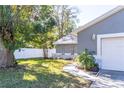 Home with gray siding, stone accents, and a walkway leading to the garage at 14004 Cascade Ln, Tampa, FL 33618