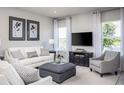 Bright living room featuring a comfy sofa and large TV at 2463 White Ladyfish Rd, Wimauma, FL 33598