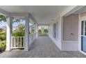 Covered front porch with tiled flooring and white railings at 4710 Parkdale Ln, New Port Richey, FL 34655