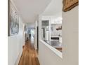 Hallway with hardwood floors and a view of the living room at 5557 Sea Forest Dr # 117, New Port Richey, FL 34652