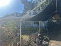 View of the home's side showcasing a covered patio area and lush landscaping at 6116 Island Dr, Weeki Wachee, FL 34607