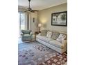 Living room features a sofa, armchair, and access to a patio at 6801 Dali Ave # G104, Land O Lakes, FL 34637