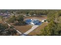 Aerial view of a white house with gray roof and detached barn on a large lot at 9331 Elida Rd, Spring Hill, FL 34608