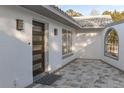 Modern dark brown front door, gray paver walkway, and white stucco exterior at 9331 Elida Rd, Spring Hill, FL 34608