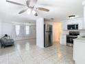 Open floor plan with tile flooring connecting the kitchen to the living area at 14034 Water Tower Dr, Hudson, FL 34667