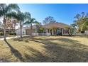 House exterior with palm trees, green lawn, and a white picket fence at 3497 Chadwick Ave, Spring Hill, FL 34609