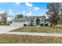 House exterior featuring a two-car garage and manicured lawn at 4438 Crescent Rd, Spring Hill, FL 34606