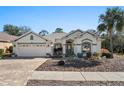 Charming single-story home featuring a well-manicured lawn and a brick driveway at 444 Quane Ave, Spring Hill, FL 34609