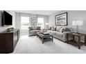 Spacious bonus room with gray sofas, a coffee table, and ample natural light at 6033 Wild Petunia Dr, Wimauma, FL 33598