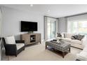 Gathering room with a neutral color palette, comfy seating, and a sliding glass door at 6033 Wild Petunia Dr, Wimauma, FL 33598