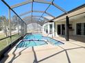 A screened-in pool features a jacuzzi-style add-on and stainless steel handrail at 6520 Pine Meadows Dr, Spring Hill, FL 34606