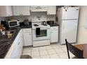 Galley kitchen with white cabinets and granite countertops at 7635 Bloomingdale Dr, New Port Richey, FL 34654