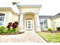 White front door entryway with columns and landscaping at 8231 Danbury Ln, Hudson, FL 34667