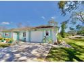 Charming light blue house with white accents and a spacious driveway, offering curb appeal at 9240 Tiara Ct, New Port Richey, FL 34655