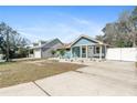 Home's exterior with a well-kept lawn, tidy landscaping, and matching detached garage providing ample parking at 1310 Georgia Ave, Dunedin, FL 34698