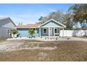 Inviting home featuring a cozy front porch swing and manicured landscaping with white rock and young palm trees at 1310 Georgia Ave, Dunedin, FL 34698