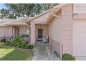 Brick-columned porch with white wicker chairs, offering a relaxing entryway at 2263 Whisper Walk Dr, Spring Hill, FL 34606
