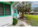 Side entrance of home near canal, featuring vibrant green trim at 5648 Riverview Dr, New Port Richey, FL 34652
