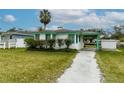 Single-story home with green trim, a carport, and a well-kept lawn at 5648 Riverview Dr, New Port Richey, FL 34652