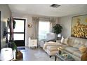 Bright living room with a sectional sofa, armchair, and access to the exterior at 6124 Chesham Dr # 6, New Port Richey, FL 34653