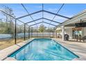 Inviting screened-in pool area perfect for relaxation and entertainment with outdoor seating and grill at 7482 Winter St, Brooksville, FL 34613
