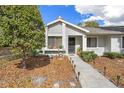 Daytime view of the front exterior with landscaped yard, walkway, and charming architectural details at 8194 Sturbridge Ct # A, Weeki Wachee, FL 34613