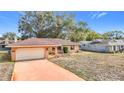 Charming single-story brick home featuring an attached garage and a well-maintained front yard at 8464 Dirlenton Way, Weeki Wachee, FL 34613