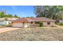 Charming single-story brick home featuring an attached garage and a well-maintained front yard at 8464 Dirlenton Way, Weeki Wachee, FL 34613