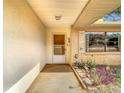 Inviting covered porch area with brick accents, decorative plants, and a security door entrance at 8464 Dirlenton Way, Weeki Wachee, FL 34613
