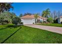 Beautiful home with a well-manicured lawn, brick driveway, and classic curb appeal at 9091 Alexandria Dr, Weeki Wachee, FL 34613