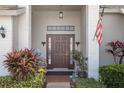 This home features a covered entryway with brick columns, sidelights, and stylish planters at 11008 Torrey Pines Ct, Hudson, FL 34667