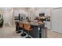 Modern kitchen boasts a large island, granite countertops, white cabinetry, and stainless steel appliances at 13357 Marble Sands Ct, Hudson, FL 34669