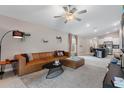 Open-concept living room with tile flooring, neutral walls, ceiling fan, and seamless flow to kitchen at 13357 Marble Sands Ct, Hudson, FL 34669