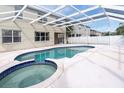 Sparkling screened-in pool and spa with clear blue water, and a neutral-colored patio, perfect for entertaining at 1442 Lenton Rose Ct, Trinity, FL 34655
