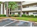 Condominium exterior and covered parking with meticulous landscaping, and building facade at 3038 Eastland Blvd # F103, Clearwater, FL 33761