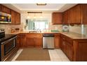 Well-maintained kitchen featuring stainless steel appliances, wood cabinetry, and neutral countertops at 3526 Overland Dr, Holiday, FL 34691