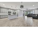 Spacious living room with an open-concept layout, modern light fixtures, tile floors and patio doors at 4066 Cloud Hopper Way, Lutz, FL 33559
