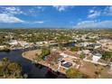 Aerial view of the waterfront property with a pool, boat dock, canal access and lush landscaping at 4115 Corn St, Port Charlotte, FL 33948