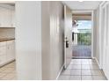 Condo foyer with tile flooring, coat closet, and a door to the outdoor patio with views of the bay at 4620 Bay Blvd # 1154, Port Richey, FL 34668