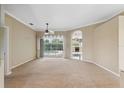 Bright and airy living room with a view of the backyard pool and an archway to another room at 6112 Kinlock Ave, Spring Hill, FL 34608
